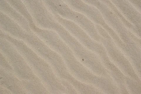 View from above, diagonal wave direction. Wind marks on the beach sand. Stock Photos