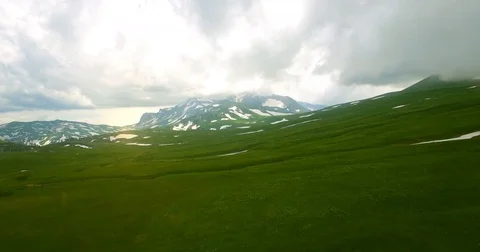 A view from above with a drone on the green grass covered with snow and snow pat Stock Footage 84745239