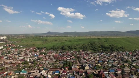 View from above from the drone to the village, in the background a green Stock Footage 213988269
