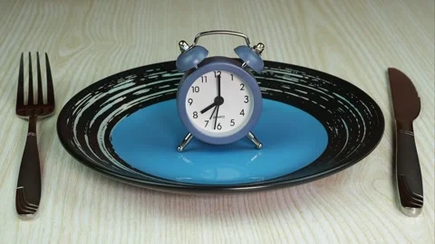 View from above on empty blue and black plate with alarm clock. Stop Motion Stock Footage 273986059
