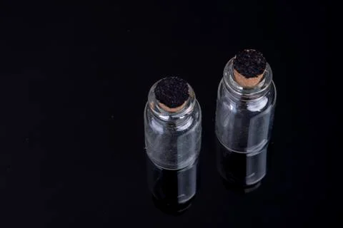 View from above empty small glass bottles with a cork closure on a black back Stock-Fotos