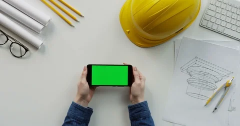 View from above on the female constructor's hands scrolling and tapping on the Stock Footage 96193619