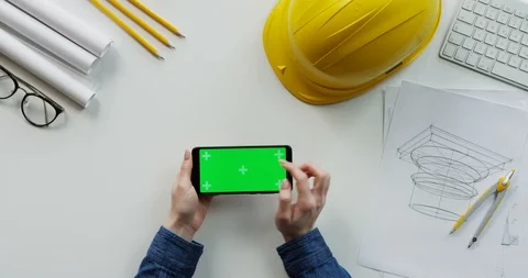 View from above on the female constructor's hands scrolling and tapping on the Stock-Footage 96193878