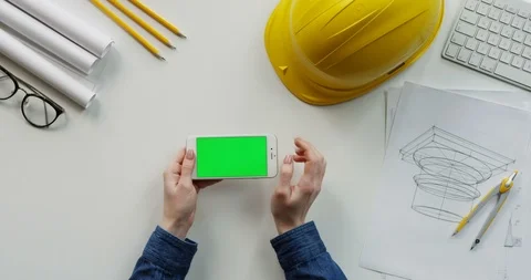 View from above on the female constructor's hands scrolling and tapping on the Video stock 96194591