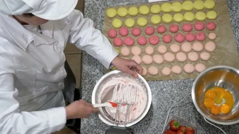 View from above, flat lay of baker hand mixing colored batter with a silicone Stock Footage 150155663