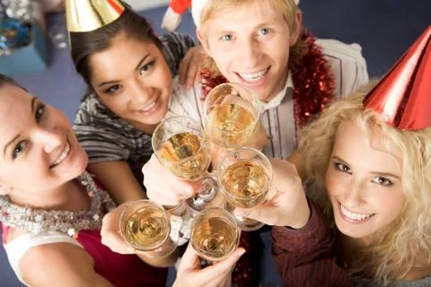 View from above of flutes fuul of champagne being held by happy friends at birth Stock Photos