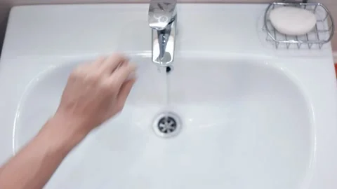 View from above. The guy turns on the water in the bathroom. Vídeos de archivo 151920338