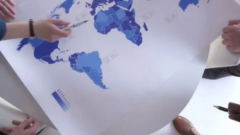 A view from above of hands on the blue world map Stock Footage 73864351