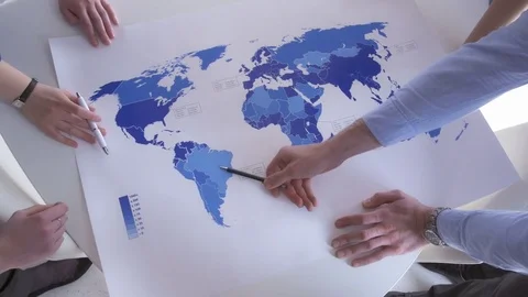 A view from above of hands on the blue world map Stock Footage 73865191