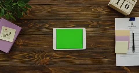 View above on the horizontal white tablet device with a green screen on the 스톡 동영상 88395591