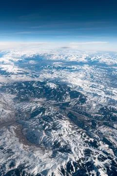 View from above of a large mountain range covered with snow in winter. Stock Photos