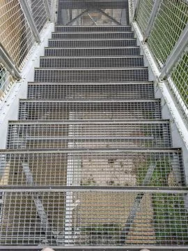 View from above long mesh staircase leading down from walkway over busy hig.. Stock Photos