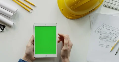 View from above on the male constructor's hands scrolling and tapping on the Stock Footage 96190216