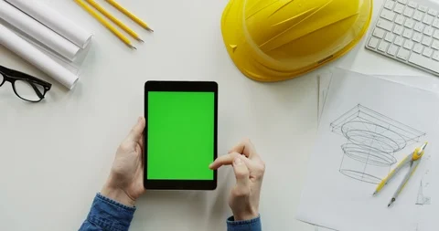 View from above on the male constructor's hands scrolling and tapping on the Stock Footage 96190568