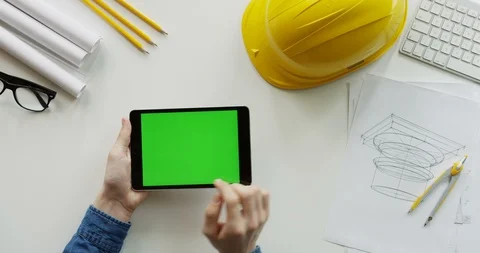 View from above on the male constructor's hands scrolling and tapping on the Stock Footage 96190731