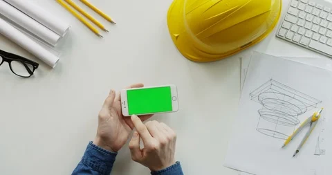 View from above on the male constructor's hands scrolling and tapping on the Stock-Footage 96190901
