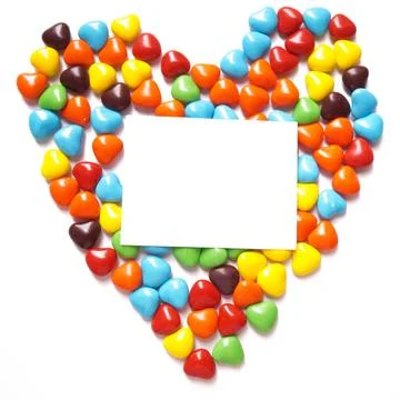 View from above on a multi-colored dragee in the shape of hearts. Postcard for Stock Photos