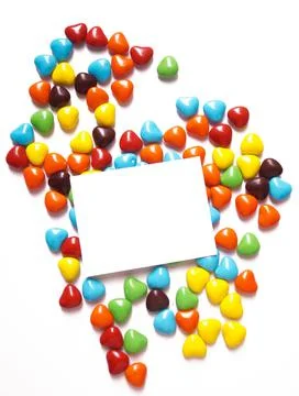 View from above on a multi-colored dragee in the shape of hearts. Postcard for Stock Photos