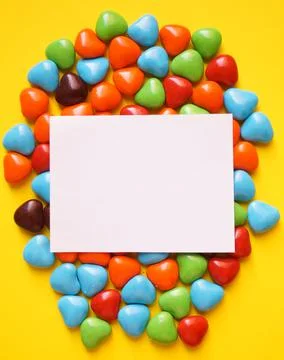 View from above on a multi-colored dragee in the shape of hearts. Postcard for Stock Photos