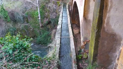 View from above of an old irrigation ditch, the river flows underneath Stock Footage 153215845