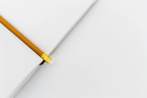 View from above of an open notepad with a pencil on a white table background Stock Photos