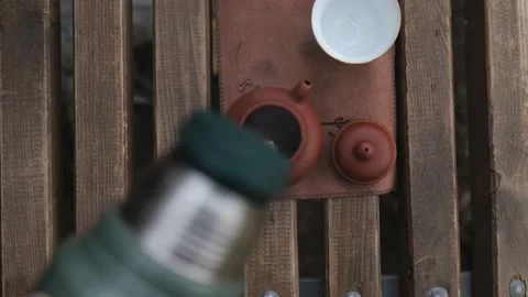 View from above. pouring boiling water from a thermos into a clay teapot Stock Footage 229860716