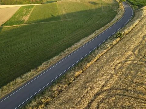 View from above of a road between grass and crop field in the countryside Stock Photos