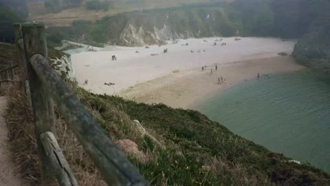 View from above of a sandy beach with blue water surrounded by mountains in Stock Footage 230272638