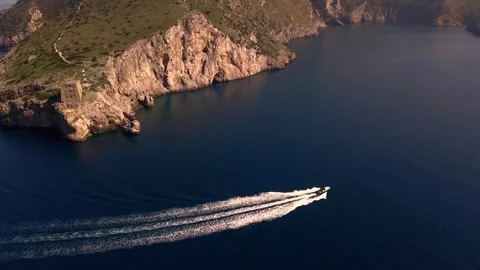 View from above of a small boat sailing along the rocks at sunset, Amalfi Coast. Stock Footage 272751761