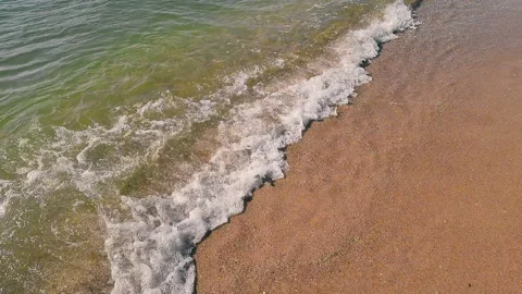 View from above on a small sea wave coming to the sandy shore of the shore Stock Footage 162620062