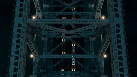 The view from above a steel-structured suspension bridge at night, traffic below Stock Footage 153470925