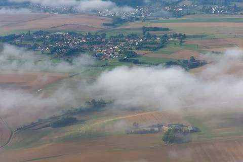 View from above through the clouds to the ground Stock Photos
