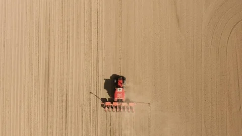 View from above, tractor working in a field. Tractor sow crops at field Stock Footage 129353288