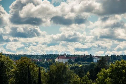 View above the trees of the green forest toward the cloister Stock Photos