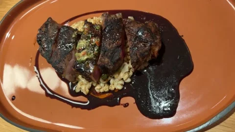 View from above on two slices of medium rare beef served with oil and seasonings Stock Footage 292696395