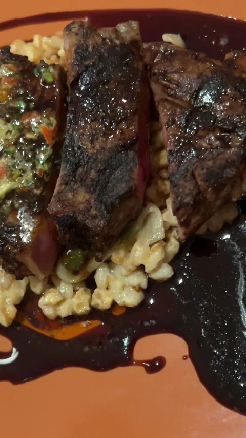 View from above on two slices of medium rare beef served with oil and seasonings Stock Footage 293253817