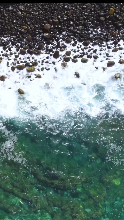 View from above of waves breaking on the unspoiled beach pebble shore Stock Footage 280025945