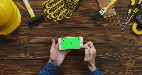 View from above on the white horizontal smartphone on the wooden desk of workman Video stock 96182615