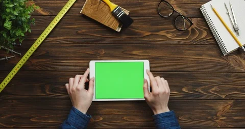 View from above on the white horizontal tablet device on the wooden desk with Stock Footage 96020345