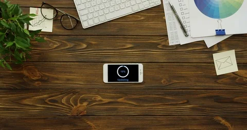 View from above on the white smartphone having a program updating on its black Stock Footage 95096027