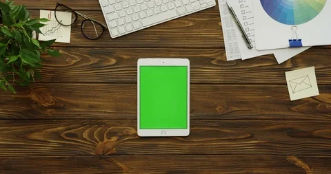 View above on the white tablet computer with a green screen lying vertically on Stock Footage 88384814