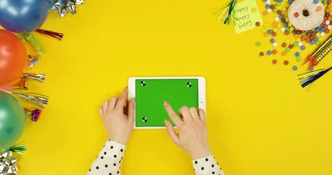 View from above on the white tablet device on the yellow table with happy Stock-Footage 89319413