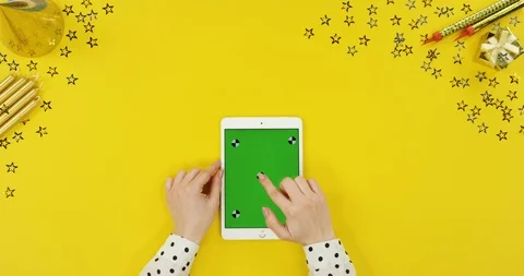 View from above on the white tablet device on the yellow table with birthday Stock Footage 89324214