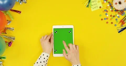View from above on the white tablet device on the yellow table with happy Stock-Footage 89336616
