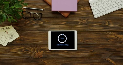 View from above on the white tablet device having a program downloading on its Stock-Footage 95063789