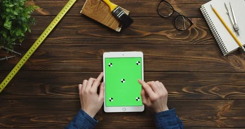 View from above on the white vertical tablet device on the wooden desk with Video stock 96021329