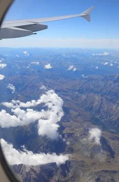View from above from window seat in flight at high altitude with wing section Stock Photos