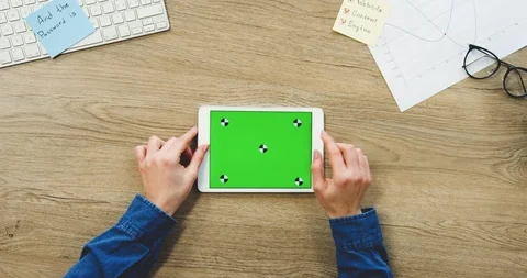 View from above on the woman's hands using the white tablet device with a green 스톡 동영상 89978855