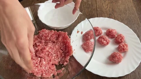 A view from above women's hands make meatballs from minced meat. The concept of Stock Footage 236389999