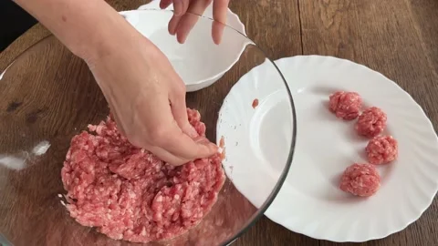 A view from above women's hands make meatballs from minced meat. The concept of Stock Footage 236390071
